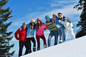 los amigos se divierten en invierno con nieve fresca foto