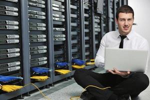 businessman with laptop in network server room photo