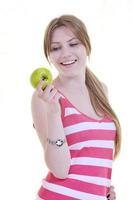 una joven feliz come manzana verde aislada en blanco foto