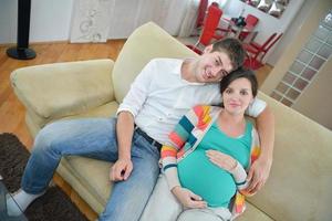 pregnant couple at home using tablet computer photo