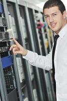 young engeneer in datacenter server room photo