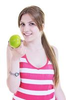 una joven feliz come manzana verde aislada en blanco foto