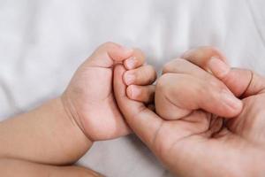 Close up baby hand on mother's hands photo