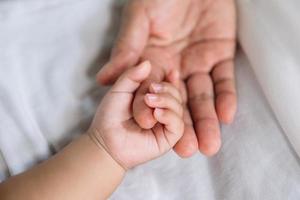 Close up baby hand on mother's hand photo