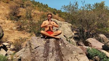 giovane uomo fare yoga nel il presto mattina nel il Highlands video