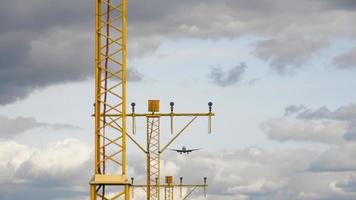 Airliner approaching the runway for landing. View from the runway front with ALS masts on the foreground, slow motion video