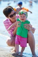 mamá y bebé en la playa se divierten foto