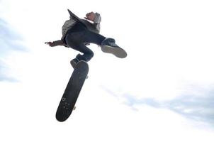 niño practicando skate en un skate park - aislado foto