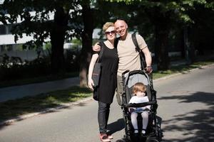 couple with baby pram in summer park photo