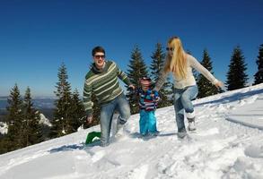 family having fun on fresh snow at winter photo
