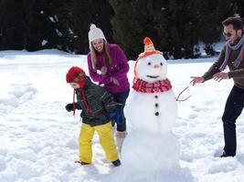 happy family making snowman photo