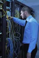 young it engineer in datacenter server room photo