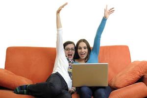 female friends working on laptop computer at home photo