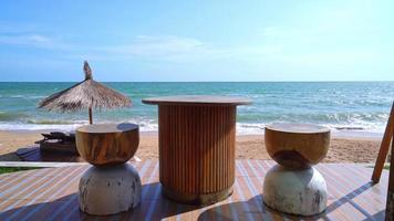 Holztisch und Stuhl auf dem Balkon mit Strandhintergrund video