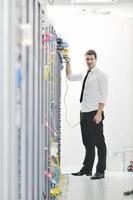 young engeneer in datacenter server room photo