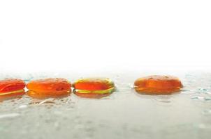 piedras zen húmedas aisladas con gotas de agua salpicadas foto