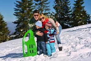 family having fun on fresh snow at winter photo