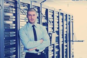 businessman with laptop in network server room photo