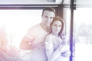 young couple enjoying morning coffee by the window photo