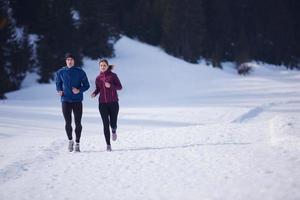 pareja trotando afuera en la nieve foto