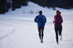 pareja trotando afuera en la nieve foto