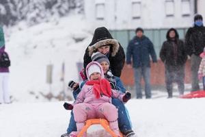 grupo de niños divirtiéndose y jugando juntos en la nieve fresca foto