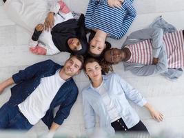 top view of a diverse group of people lying on the floor and symbolizing togetherness photo