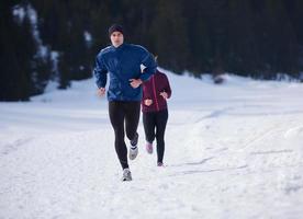 pareja trotando afuera en la nieve foto