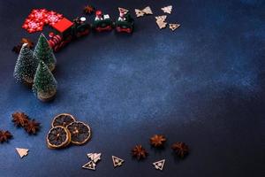 elementos de decoración navideña, dulces y pan de jengibre en una tabla para cortar madera foto