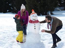 happy family making snowman photo