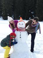 happy family making snowman photo