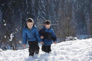 niños jugando con nieve fresca foto