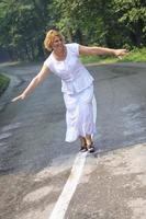 middle age woman walk on white line on road outdoor photo