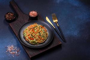 Fresh salad of sliced thin strips of carrot and zucchini on a concrete background photo