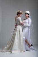 Portrait of two beautiful young bride in wedding dresses photo