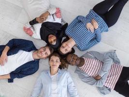 top view of a diverse group of people lying on the floor and symbolizing togetherness photo