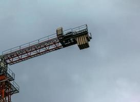 Construction crane against the blue sky. The real estate industry. A crane uses lifting equipment at a construction site. photo