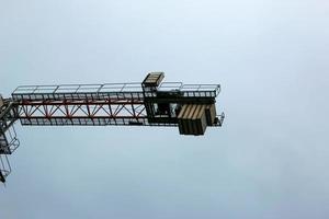 Construction crane against the blue sky. The real estate industry. A crane uses lifting equipment at a construction site. photo