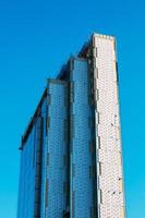 Looking up blue modern office building. A building made of glass and metal in the process of cladding with glass and metal. photo