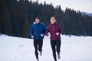 pareja trotando afuera en la nieve foto