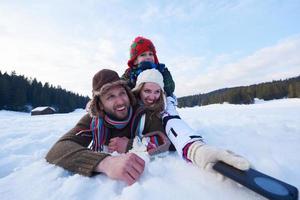 pareja romántica divertirse en la nieve fresca y tomar selfie foto