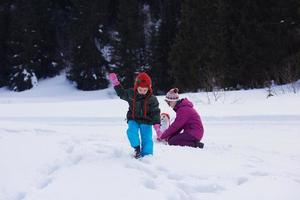 familia feliz construyendo muñeco de nieve foto