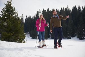 couple having fun and walking in snow shoes photo