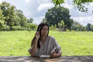 Asian female gardeners are meditating gathering ideas to find new ideas in their garden. photo