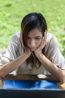 Asian woman gesturing while staring at something on a laptop screen photo