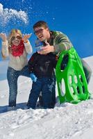 familia divirtiéndose en la nieve fresca en invierno foto