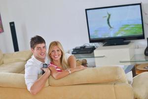 Relaxed young  couple watching tv at home photo