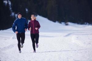 pareja trotando afuera en la nieve foto