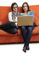 female friends working on laptop computer at home photo