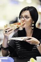 mujer come pizza en el restaurante foto